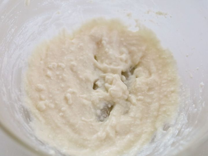 絹ごし豆腐と米油を泡立て器で混ぜ合わせたなめらかな白い生地をボウルに入れた俯瞰写真