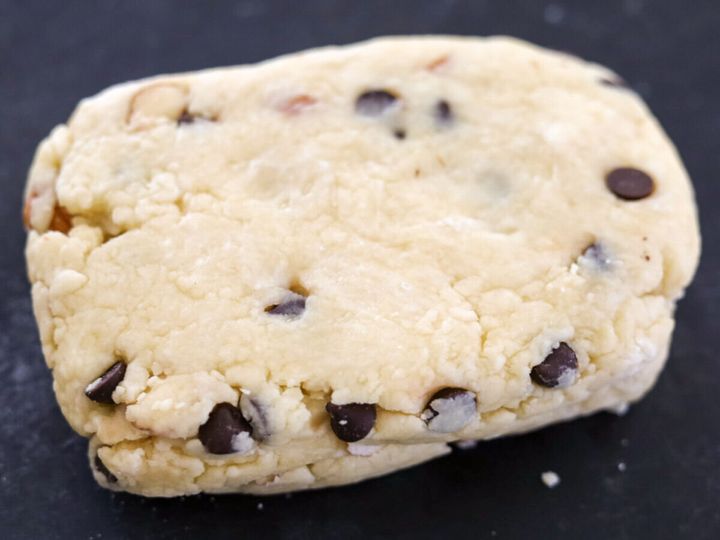 チョコチップとアーモンドが入った生地をひとまとめにして黒い作業台に出した状態