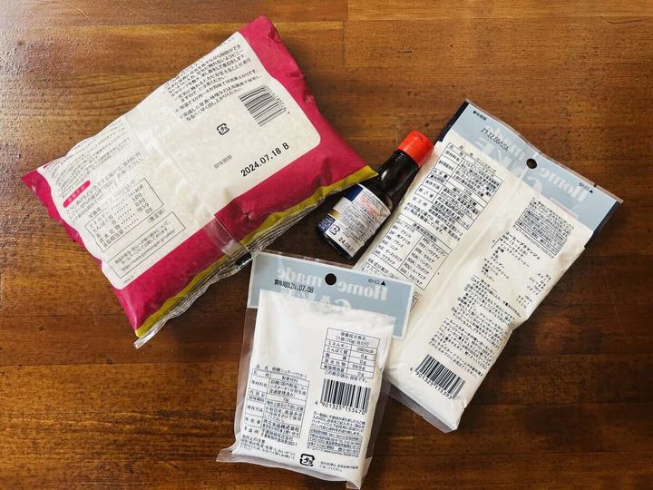 木製テーブルに置かれた開封済みの粉類の袋2つと小さな調味料ボトル。賞味期限の印字が見える俯瞰写真