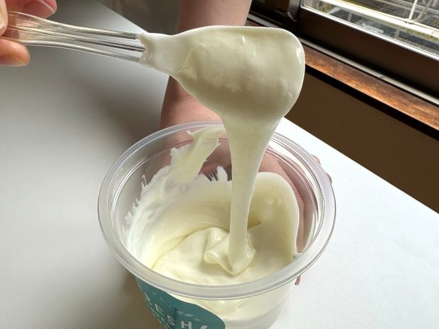 フレッシュよーグルグルトがとろとろに変化してスプーンから糸を引く様子