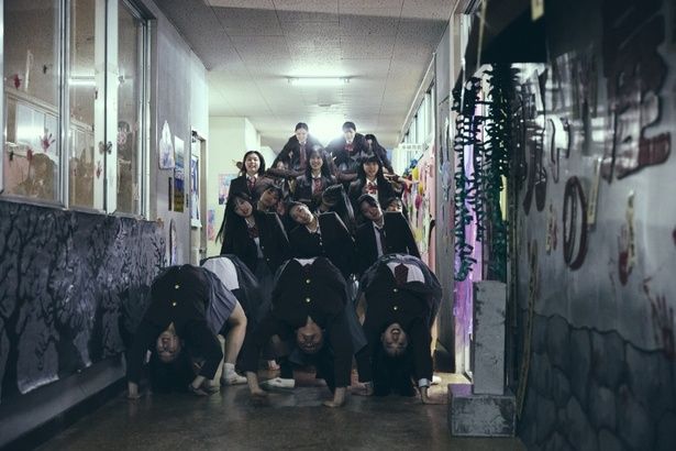 異様な組体操によって追いつめられるシーンはインパクト抜群 [c]2026映画「NEW GROUP」製作委員会