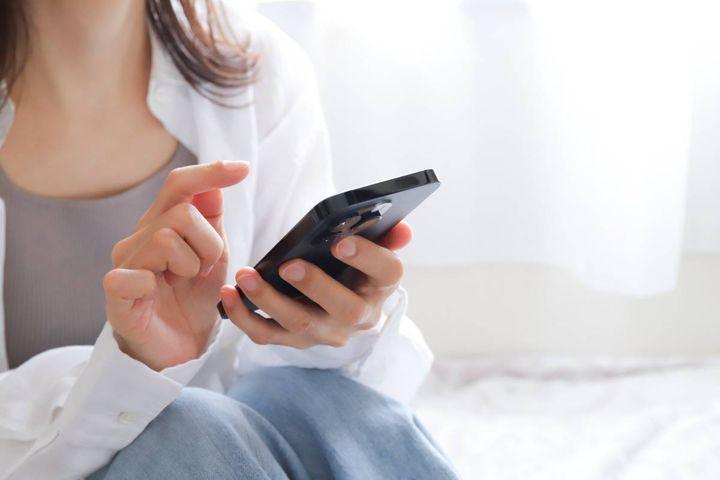 スマートフォンを見る女性の手