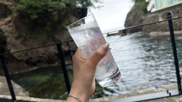 ジントニックのグラスを持つ手