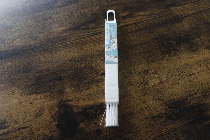 白いサッシ用ほうき＆ちりとりセットが木目調のテーブルに置かれている俯瞰
