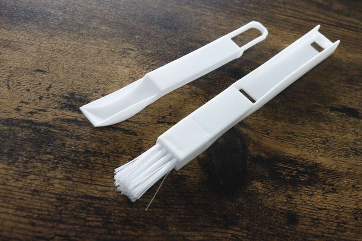 白いサッシ用ほうきとちりとりが分離され木目調のテーブルに並ぶ