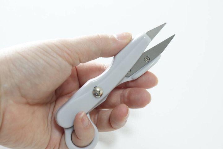 白い「指通し付にぎりハサミ」を右手が握っている様子