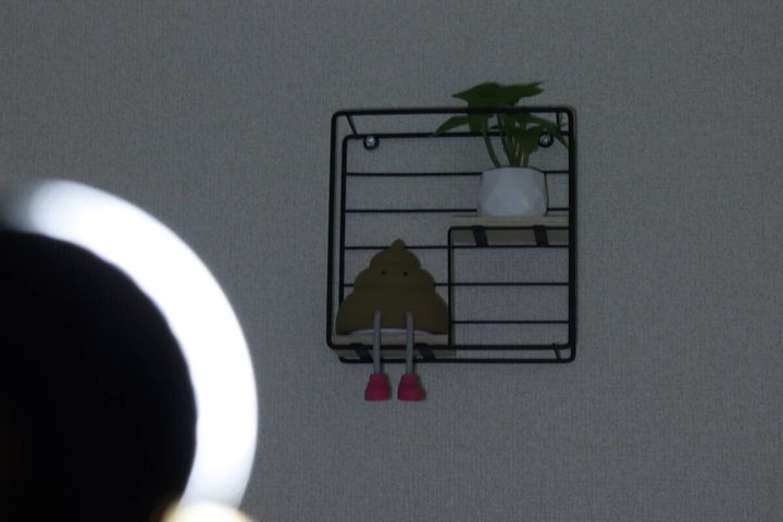 暗い部屋でライトのCOBモードHighを壁の棚に当てて照らしている