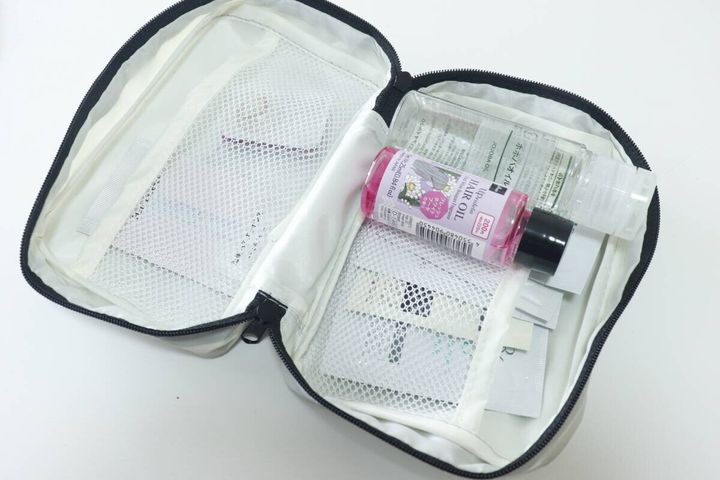 グレーのポーチにサンプルコスメやヘアオイルを収納している様子