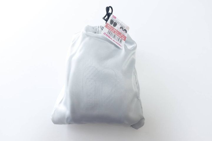 巾着に入ったグレーのポケッタブルスリッパと商品タグ