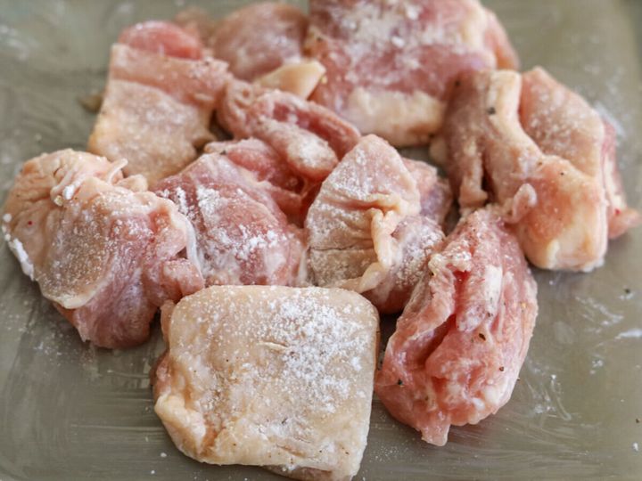 一口大に切った鶏もも肉に片栗粉をまぶし、白い粉がついた状態のアップ写真