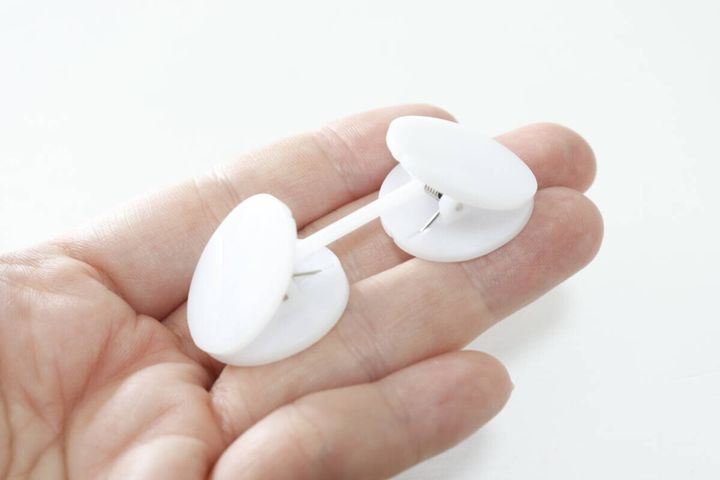 白いカーテンレースクリップが手のひらに乗っている