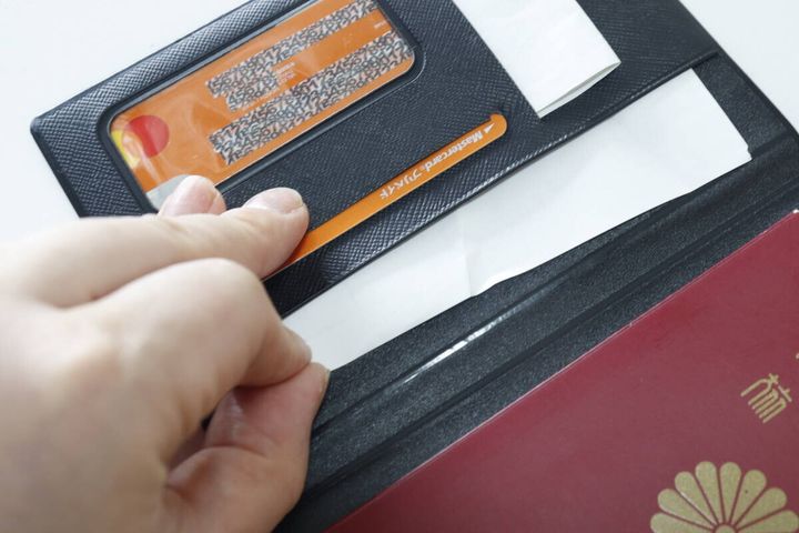 パスケースを開き、カードやレシートを収納する様子
