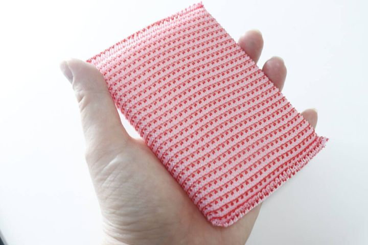 手のひらに乗せた赤いキッチンスポンジタワシ