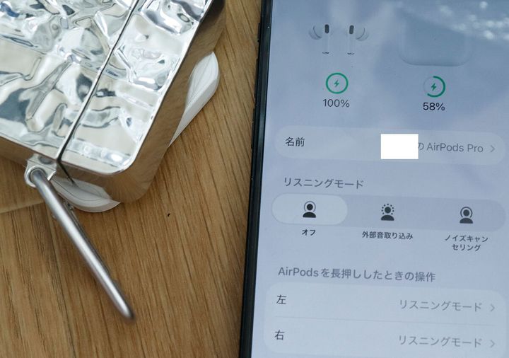 イヤホンケースに入ったAirPods Proと充電状況を示すスマホ画面