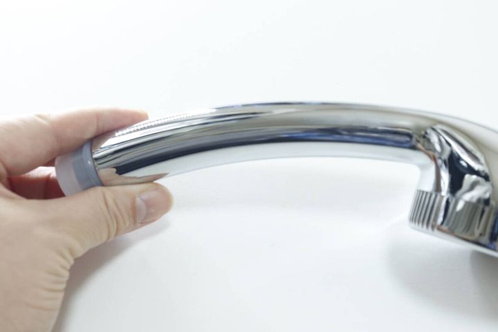 シャワーヘッドのカーブしたハンドル部分を指で持っている側面