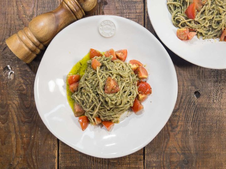 白い皿に盛り付けられたしそベーゼパスタとミディトマト。奥にもう一皿。