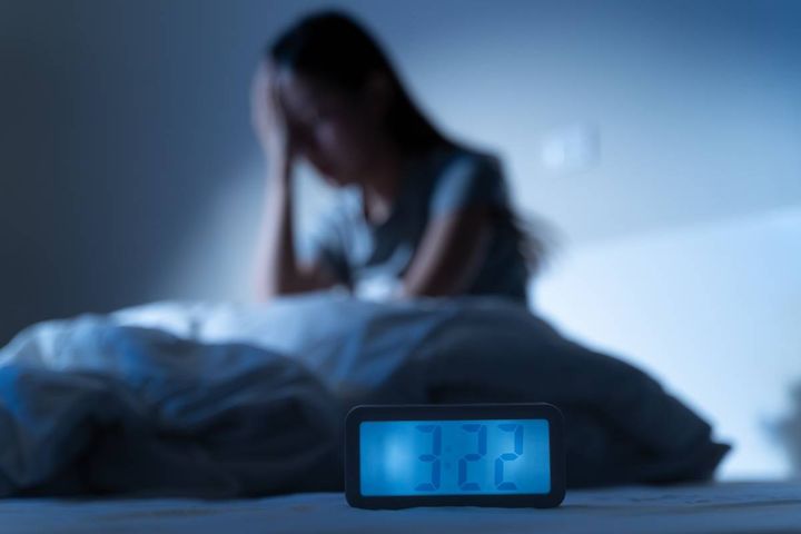 夜ベッドで眠れない女性