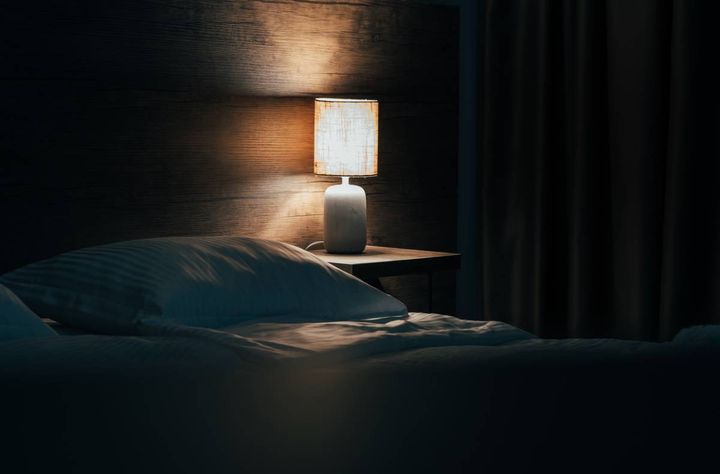 夜のベッドと枕元の灯り