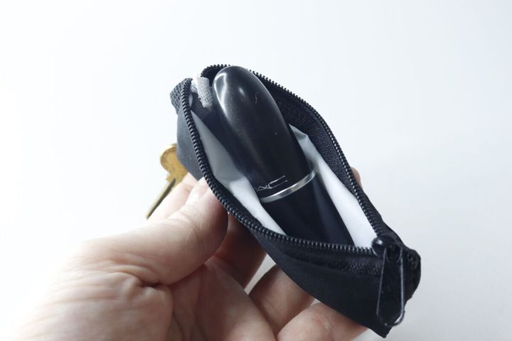 開いた黒いミニポーチに、黒いリップスティックが収まっている。