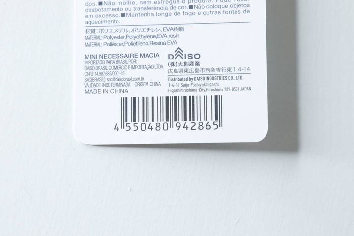 黒いミニポーチの商品タグ裏面。バーコードと詳細情報。