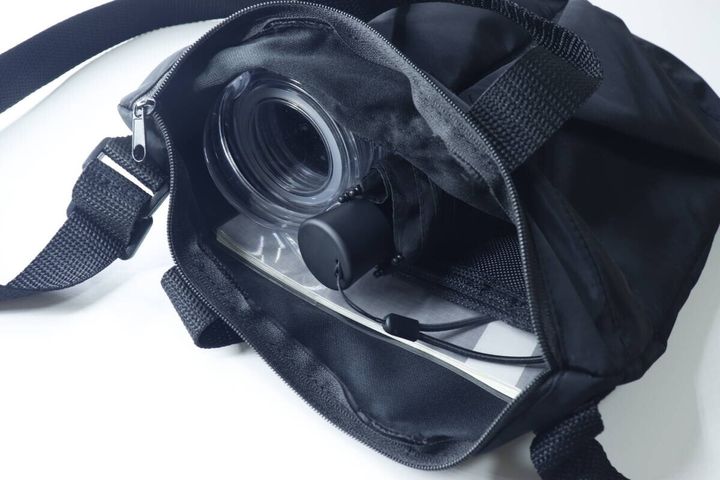 黒い2WAYショルダーバッグのメイン収納に長財布や水筒などが入っている様子