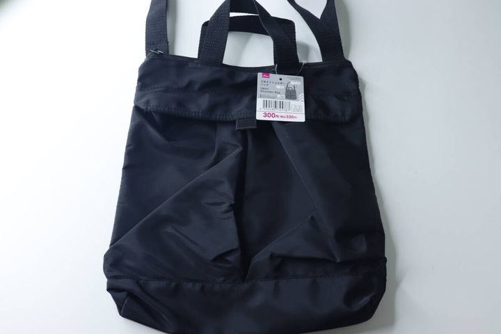 黒い2WAYショルダーバッグが白い背景に置かれ、商品タグが付いている状態