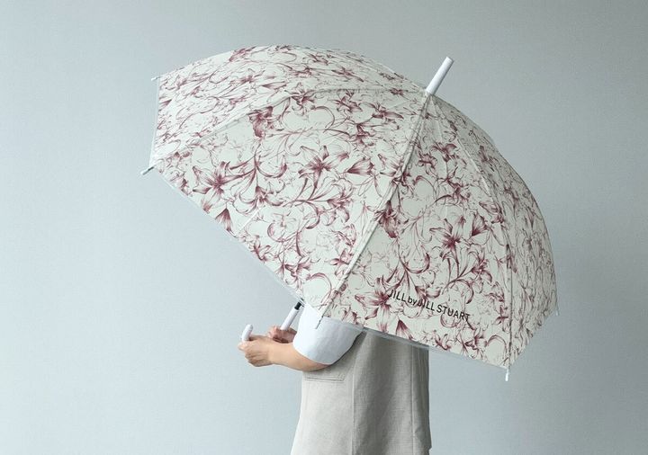 リリーの花柄の傘を差して立っている人物の後ろ姿