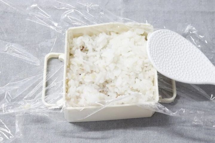 白いご飯冷凍保存型にラップを敷き、ご飯を入れ、しゃもじが添えられている