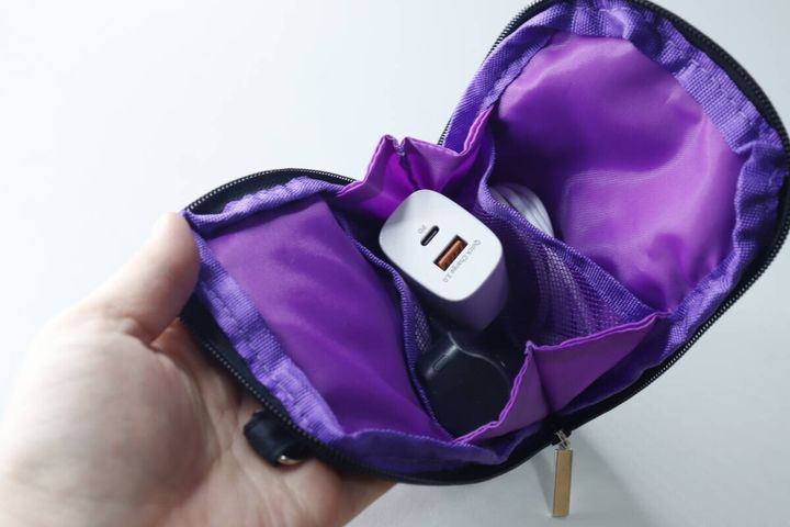 紫色のポーチのメッシュポケットに充電器とケーブルが収納されている