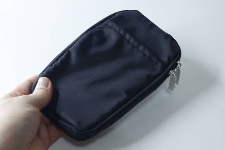 手に持たれた黒い携帯ショルダーポーチの側面