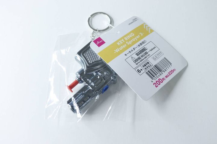 透明な袋に入ったダイソーのメタリックな水鉄砲キーホルダー