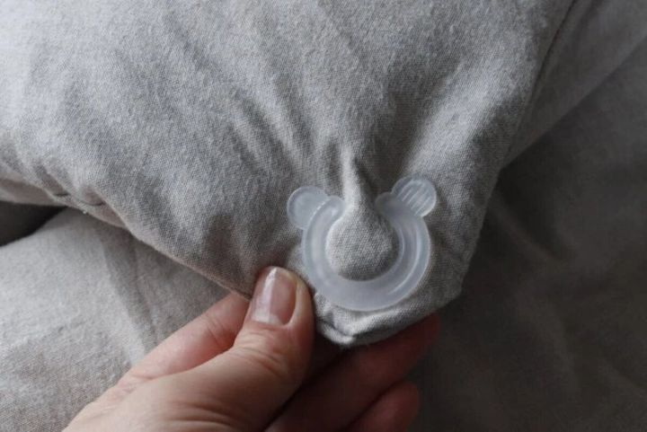 布団カバーの端を半透明のクリップで挟んでいる手