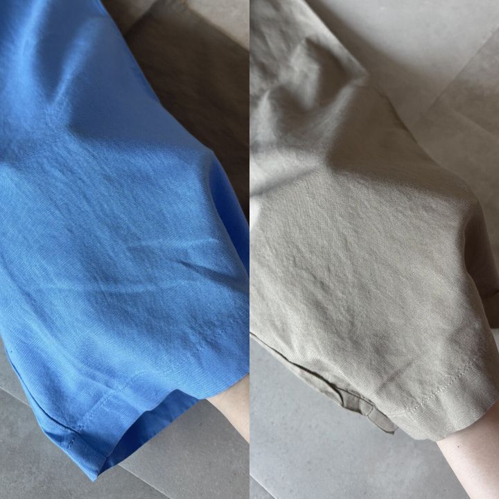 ブルーとベージュのパンツの生地を指でつまんで質感を見せている