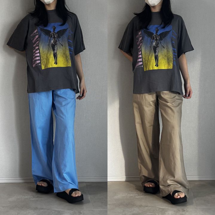 グレーのロゴTシャツとブルー・ベージュパンツを履いた女性