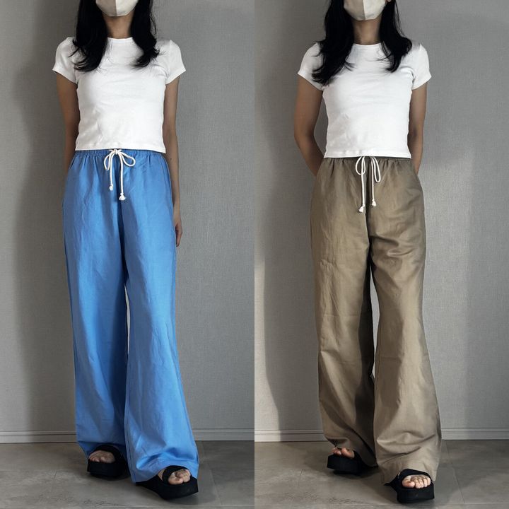 白Tシャツとブルー・ベージュパンツを履いた女性の全身正面