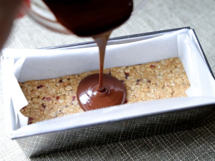 パウンドケーキ型に敷き詰めたオートミール生地の上に、溶かしたダークチョコレートがとろりと注がれている。