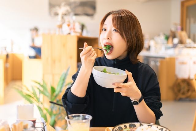 カフェでサラダを食べる女性