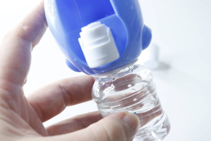 手でミニウォーターサーバーのタンクを本体にセットしている様子