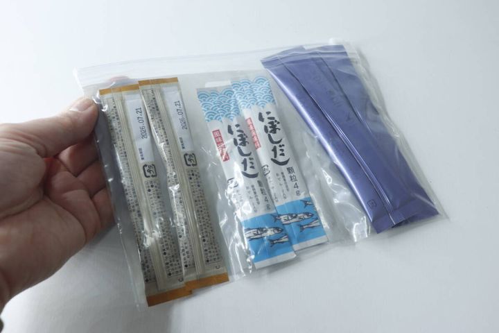 手に持ったスライダーバッグにスティックシュガーと顆粒だしが収納されている