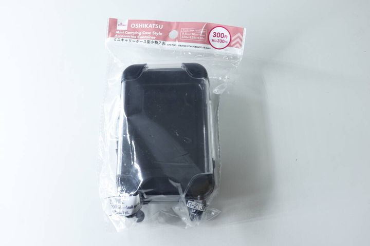透明な袋に入った黒いミニキャリーケース型小物入れ