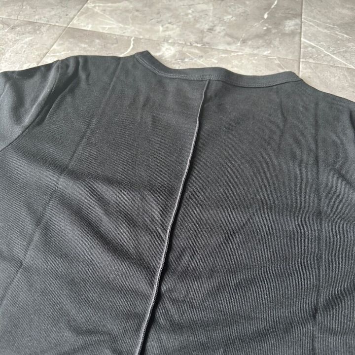 黒いシアーTシャツの背中部分にあるメローデザインの縫い目をアップで写している