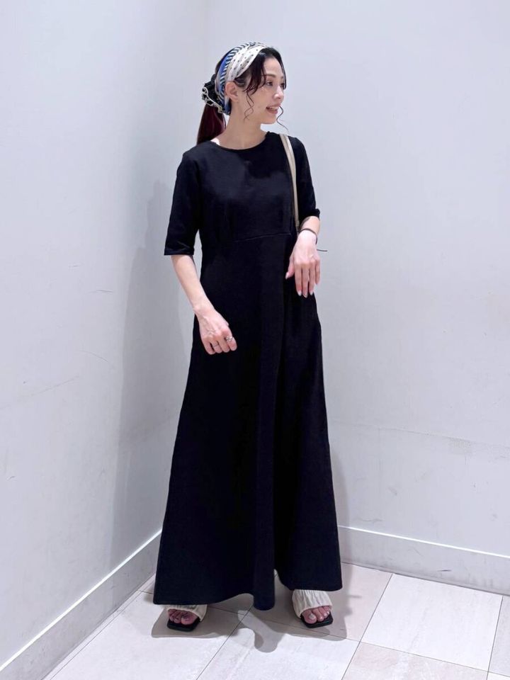 黒いフレアワンピースを着た女性、頭にスカーフを巻いて横向き