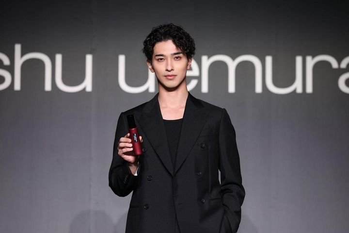画像: シックな黒のダブルスーツ姿で現れた横浜さん 出典：シュウ ウエムラ
