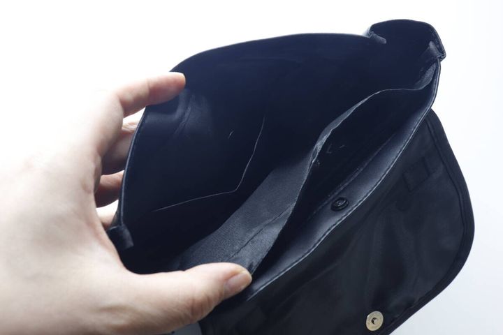 黒いバッグの蓋を開けて内部の仕切りとポケットを見せている