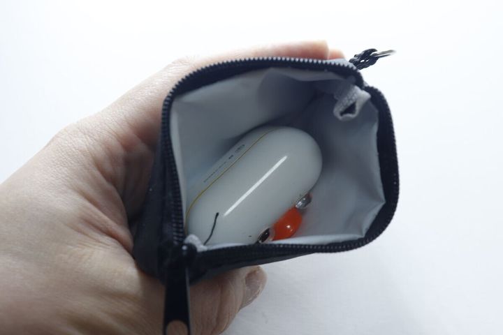 ポーチの中に白いワイヤレスイヤホンケースが収納されている