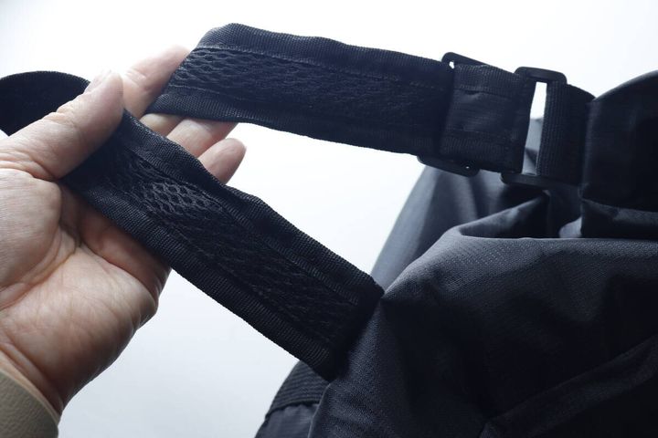 手でバッグのショルダーベルトのメッシュ素材を確認している