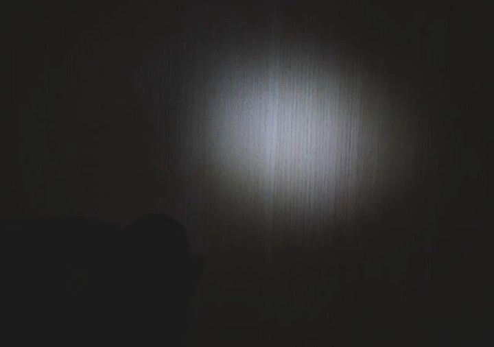 暗い部屋の壁をLEDライトの光が丸く照らしている