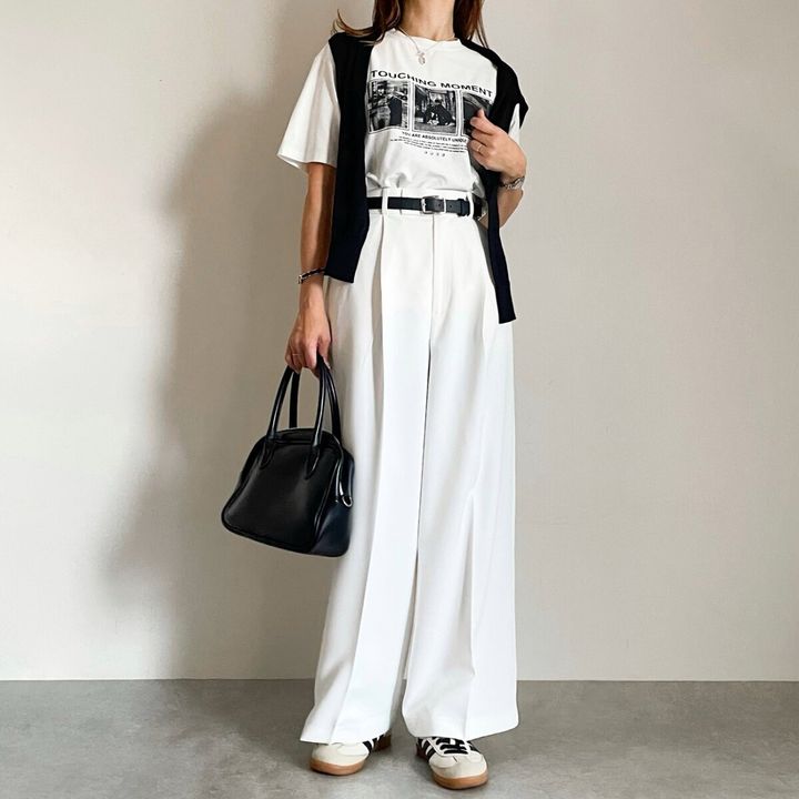 白ワイドパンツにフォトTと黒カーデを羽織った女性