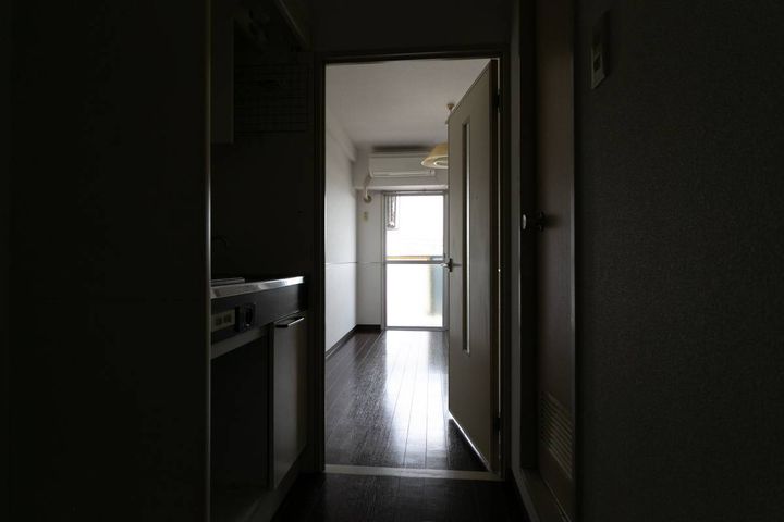 薄暗い玄関から見た、ワンルームの新居の室内