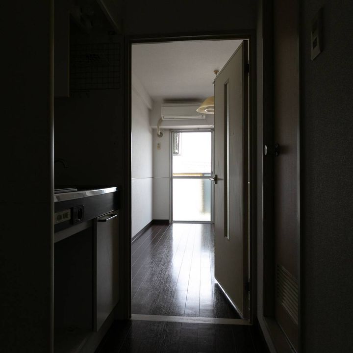 薄暗い玄関から見た、ワンルームの新居の室内